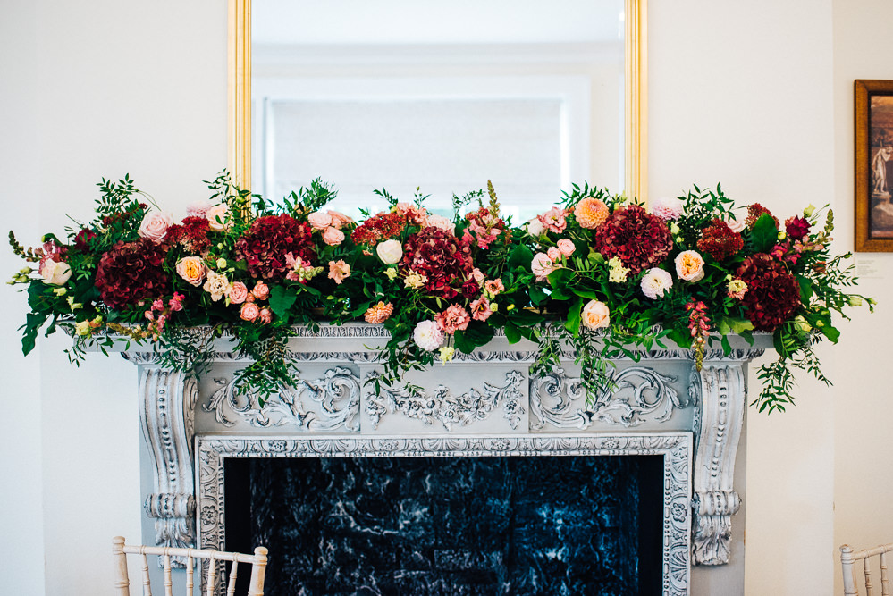 Fireplace Mantle Flowers Burgundy Hydrangea Orange Daliah Rose Greenery Foliage Pembroke Lodge Wedding Mark O'Brien Photography