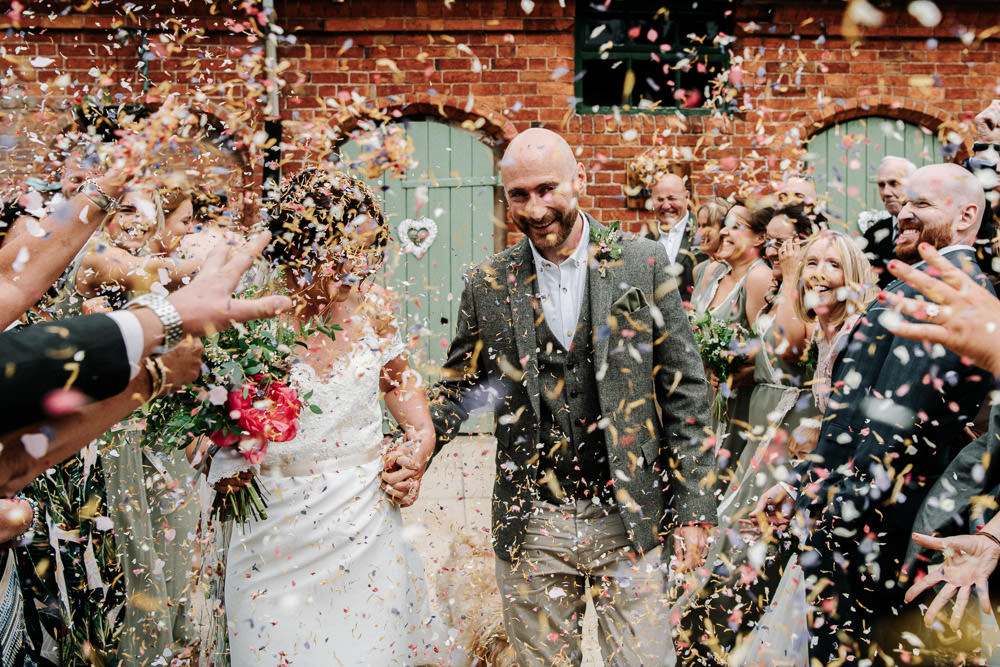 Bride Bridal Dress Gown Lace Detail Drop Cold Shoulder Ribbon Bow Sleeveless Tweed Suit Waistcoat Groom Floral Veil Confetti Stanford Farm Wedding Andy Griffiths Photography