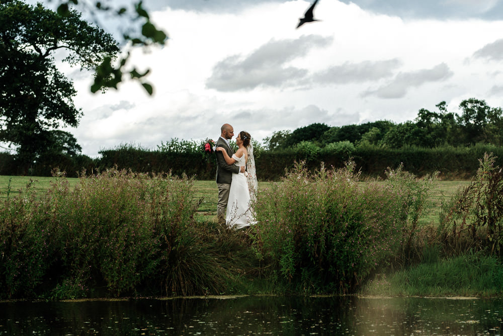 Bride Bridal Dress Gown Lace Detail Drop Cold Shoulder Ribbon Bow Sleeveless Tweed Suit Waistcoat Groom Floral Veil Stanford Farm Wedding Andy Griffiths Photography