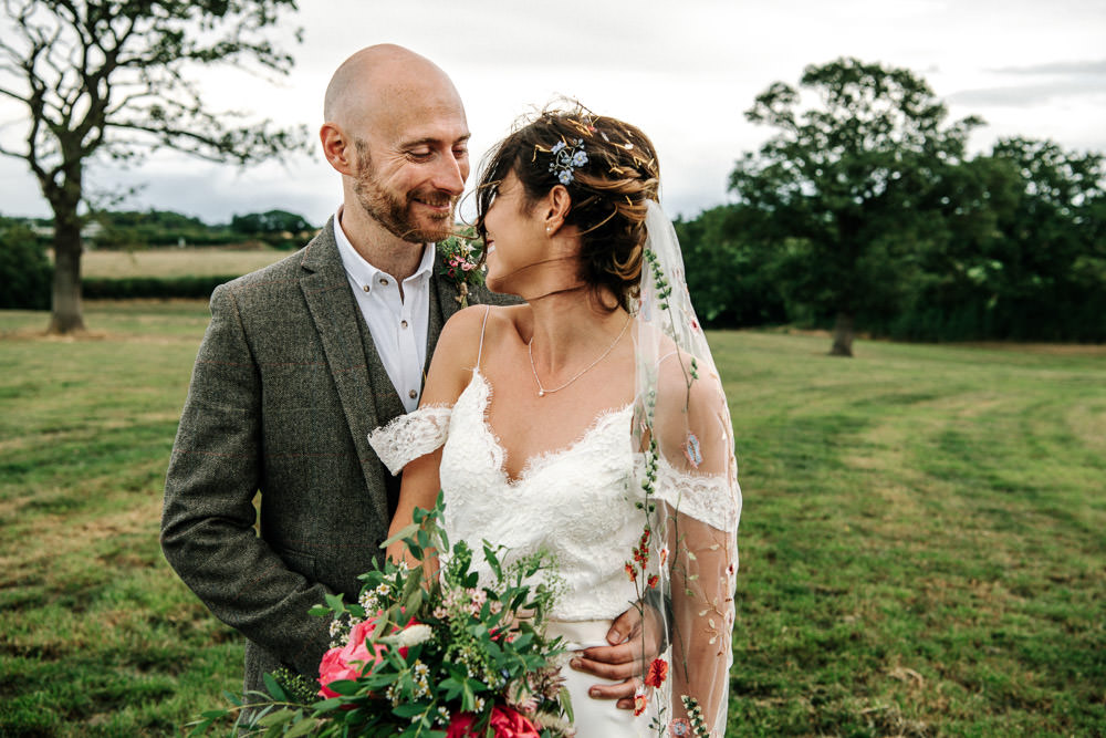 Bride Bridal Dress Gown Lace Detail Drop Cold Shoulder Ribbon Bow Sleeveless Tweed Suit Waistcoat Groom Floral Veil Bouquet Stanford Farm Wedding Andy Griffiths Photography