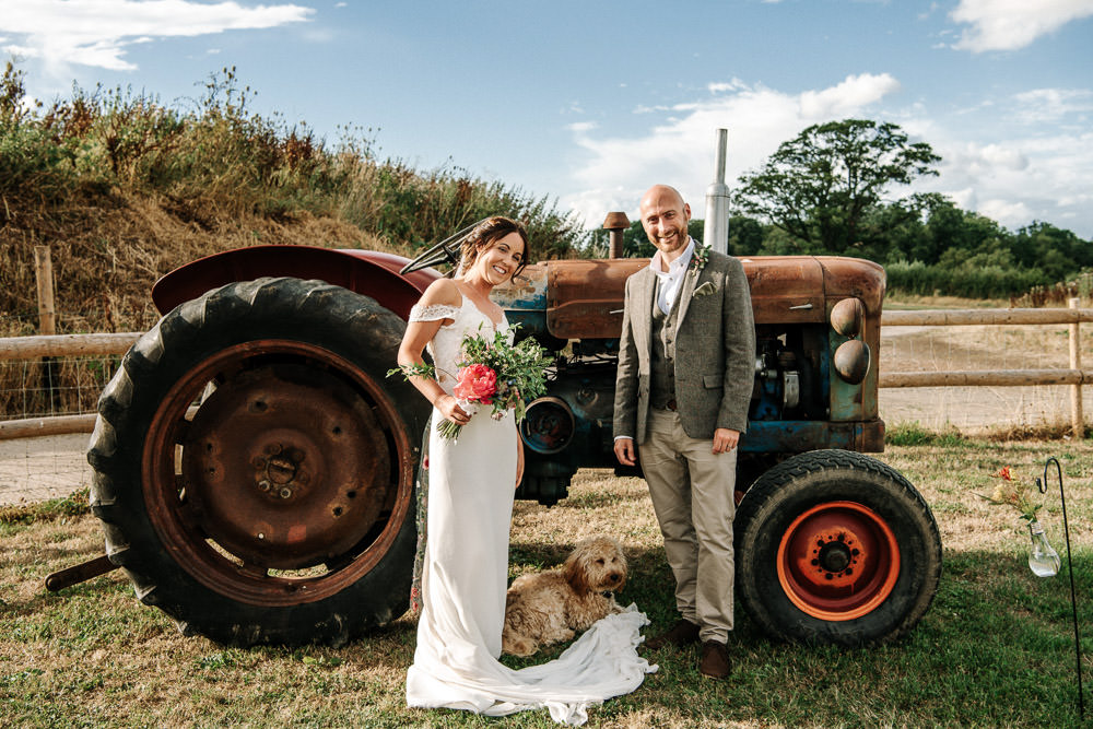 Bride Bridal Dress Gown Lace Detail Drop Cold Shoulder Ribbon Bow Sleeveless Tweed Suit Waistcoat Groom Floral Veil Stanford Farm Wedding Andy Griffiths Photography
