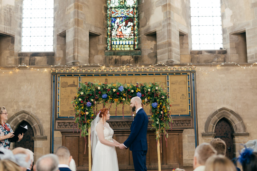 Bride Bridal Sweetheart Overlay Dress Navy Suit Groom Tweed Waistcoat Multicoloured Floral Arch Left Bank Leeds Wedding Amber Marie Photography