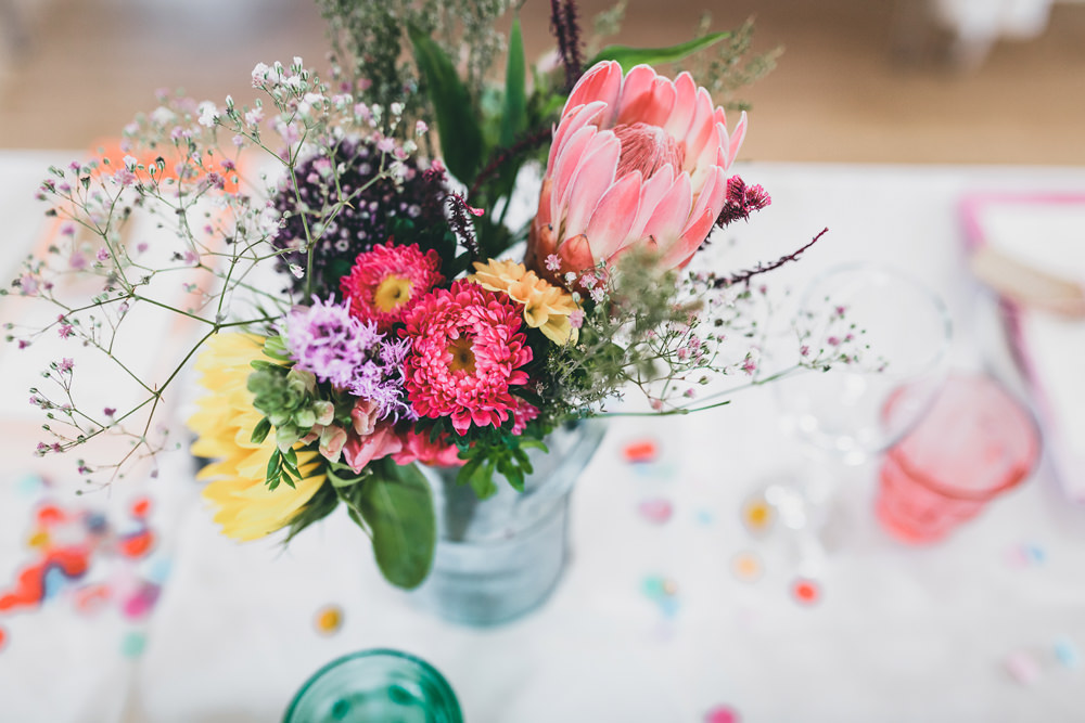 Milk Churn Table Flowers Centrepiece Colourful Decor Protea Rock Village Hall Wedding Lucie Hamilton Photography