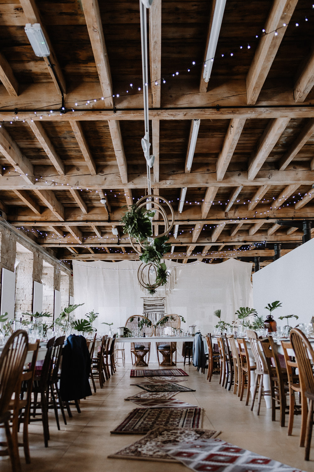 Bohemian Reception Room Decor Macramé Persian Rugs Hanging Hoops Greenery Foliage Peacock Chairs Botanical Industrial Wedding Caitlin and Jones Photography