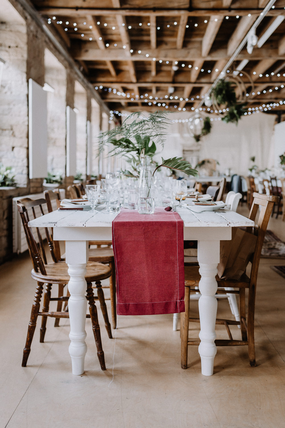 Bohemian Reception Room Decor Persian Rugs Hanging Hoops Greenery Foliage Wooden Chairs Botanical Industrial Wedding Caitlin and Jones Photography