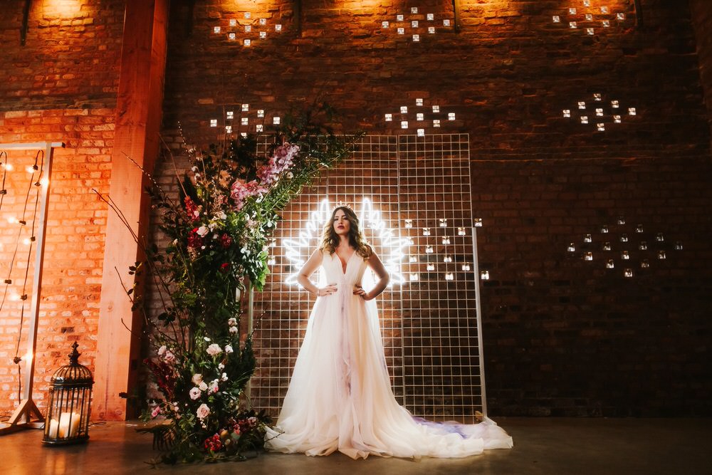 Flower Installation Backdrop Neon Sign Greenery Foliage Metal Bride Bridal Dress Gown Train Tulle Romantic Wedding Ideas Neon Lighting Kate McCarthy Photography