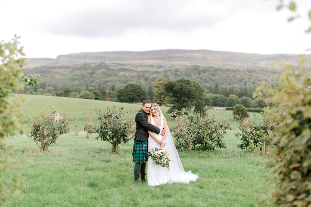 Bride Bridal Deep V Plunge Neckline Dress Sleeveless Slim Fit Ogilvie Tartan Kilt Groom Veil Bouquet Greenery Foliage Tin Shed Knockraich Farm Wedding The Gibsons Photography