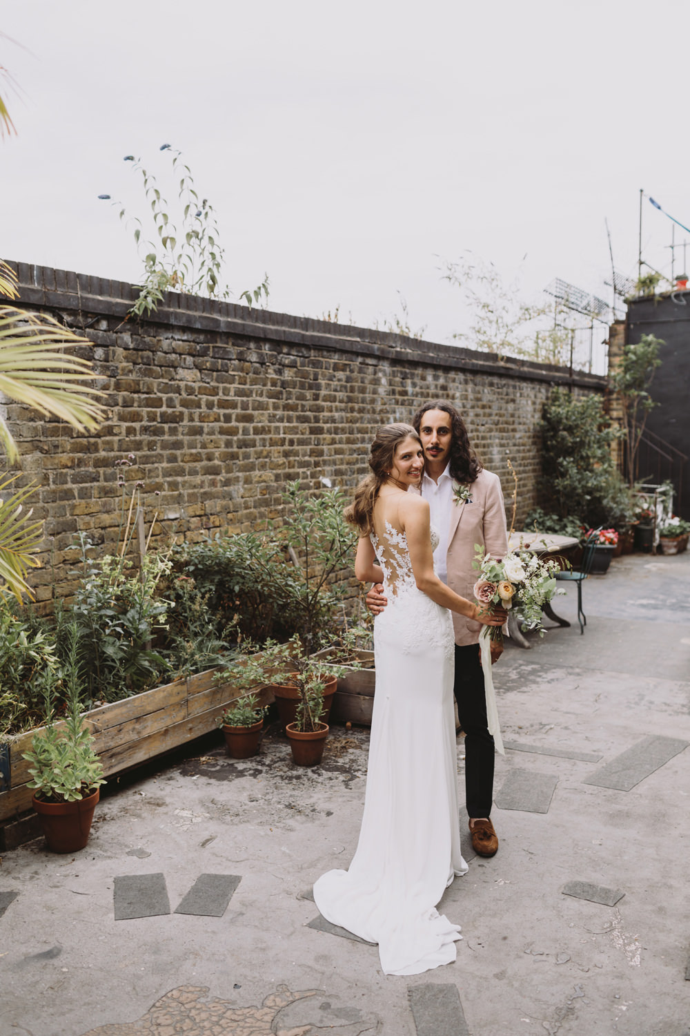 Bride Bridal Sleeveless V Neck Fit and Flare Train Pronovias Dress Gown Pink Jacket Reiss Groom Wild Bouquet Loose Handtied Rose Illusion Back Lace Tram House Wedding Luke Hayden Photography