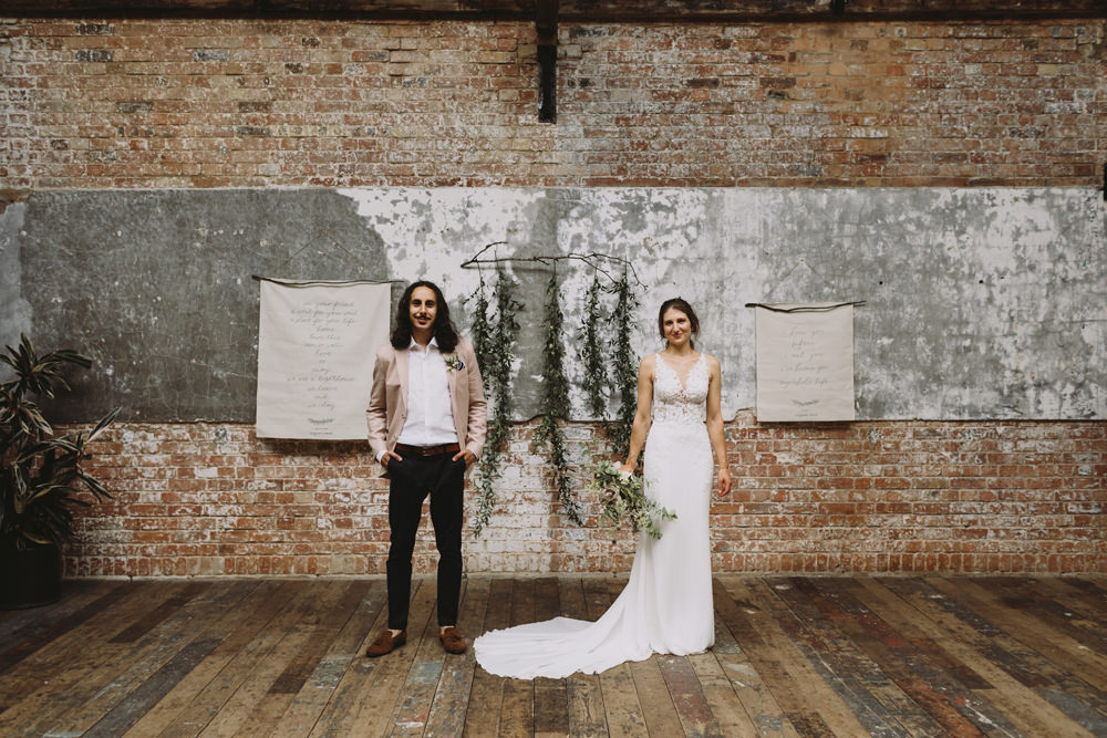 Bride Bridal Sleeveless V Neck Fit and Flare Train Pronovias Dress Gown Pink Jacket Reiss Groom Wild Bouquet Loose Handtied Rose Industrial Ceremony Hanging Banner Foliage Tram House Wedding Luke Hayden Photography
