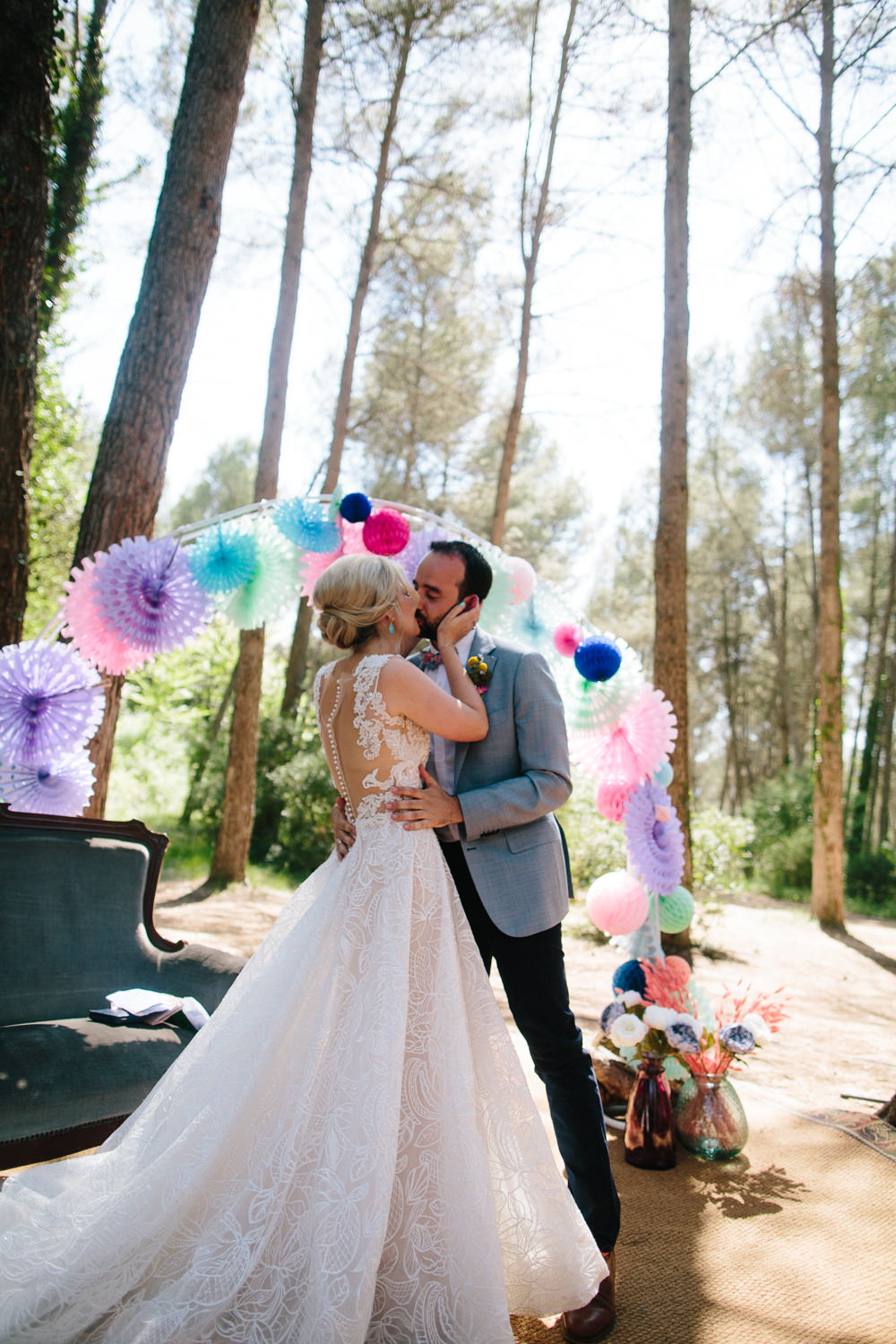 Bride Bridal Lace Strappy Sleeveless Embellished Dress Gown Mismatched Bow Tie Groom Bright Coloured Pin Wheel Paper Lantern Arch Forest Spain Destination Wedding Dan Hough Photography