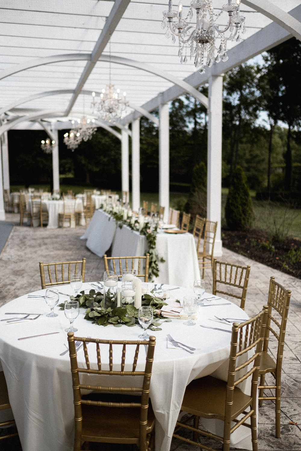 Outdoor Pool Reception Venue Round Tables Gold Chairs Greenery Swag Runner Foliage Missouri Wedding Nick Mehn Photography
