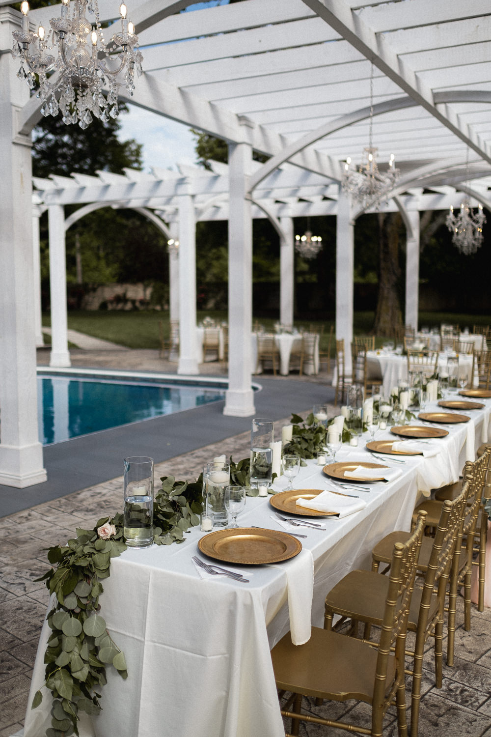 Outdoor Pool Reception Venue Long Tables Gold Chairs Greenery Swag Runner Foliage Missouri Wedding Nick Mehn Photography