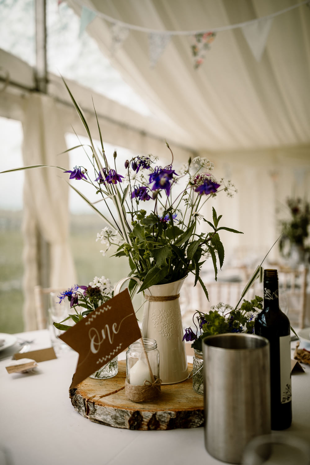 Centrepiece Table Decor Decorations Log Slice Jug Flowers Purple Pennant Flag Table Name Candle Yorkshire Barn Wedding Hayley Baxter Photography