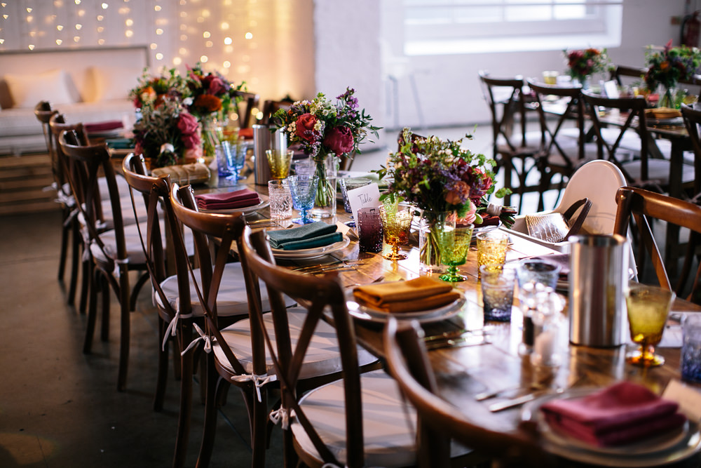 Long Tables Wooden Cross Back Chairs Colourful Lanterns Flowers Napkins Bridal Jumpsuit Wedding Emily Jarrett Photography