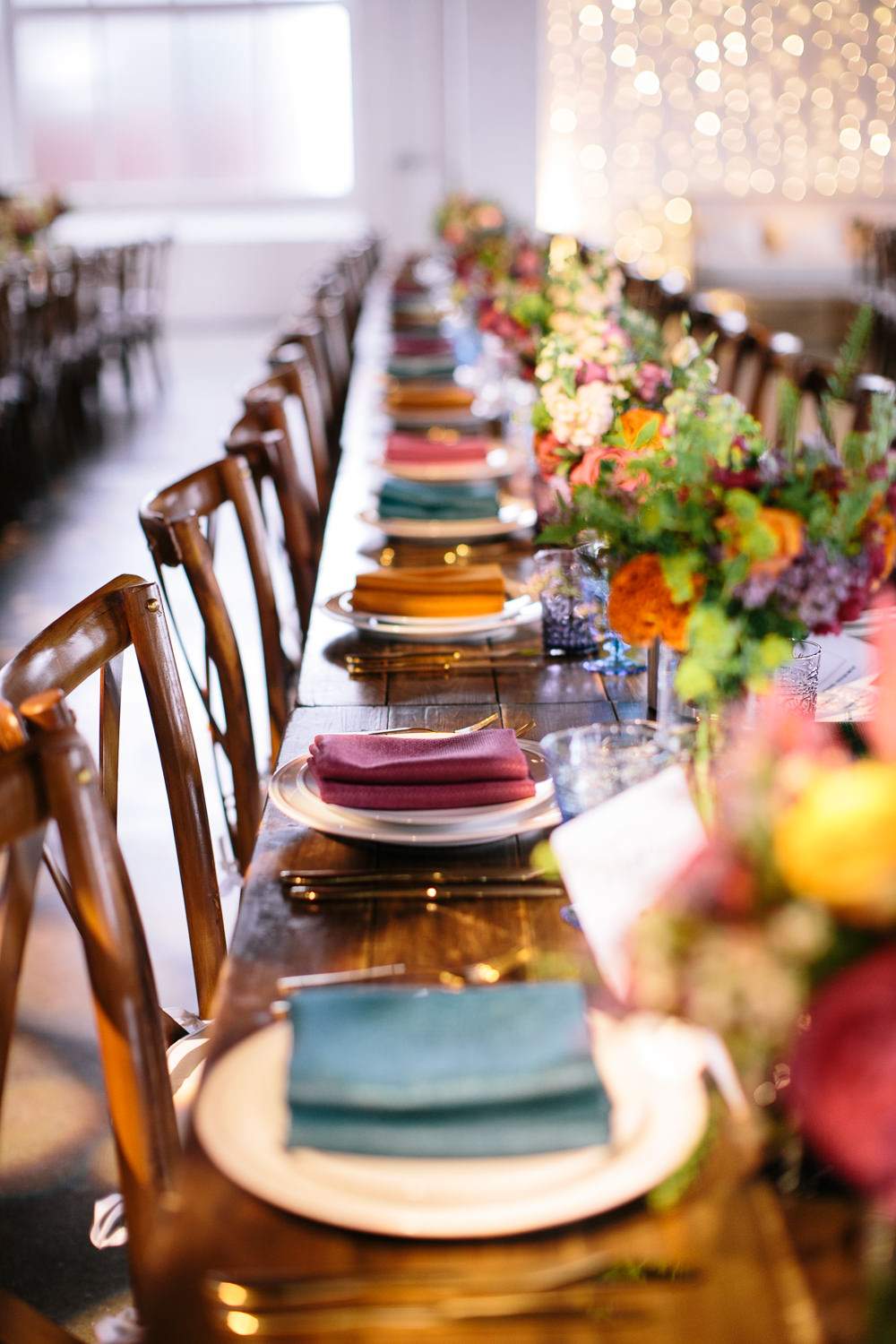 Long Tables Wooden Cross Back Chairs Colourful Lanterns Flowers Napkins Bridal Jumpsuit Wedding Emily Jarrett Photography