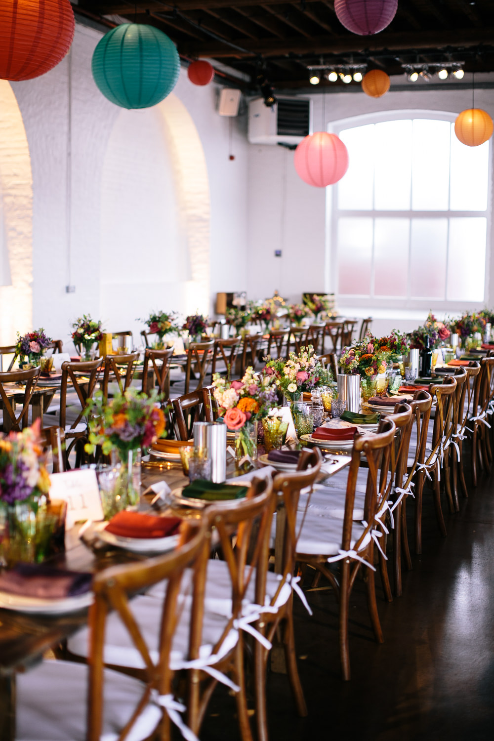 Long Tables Wooden Cross Back Chairs Colourful Lanterns Flowers Napkins Bridal Jumpsuit Wedding Emily Jarrett Photography