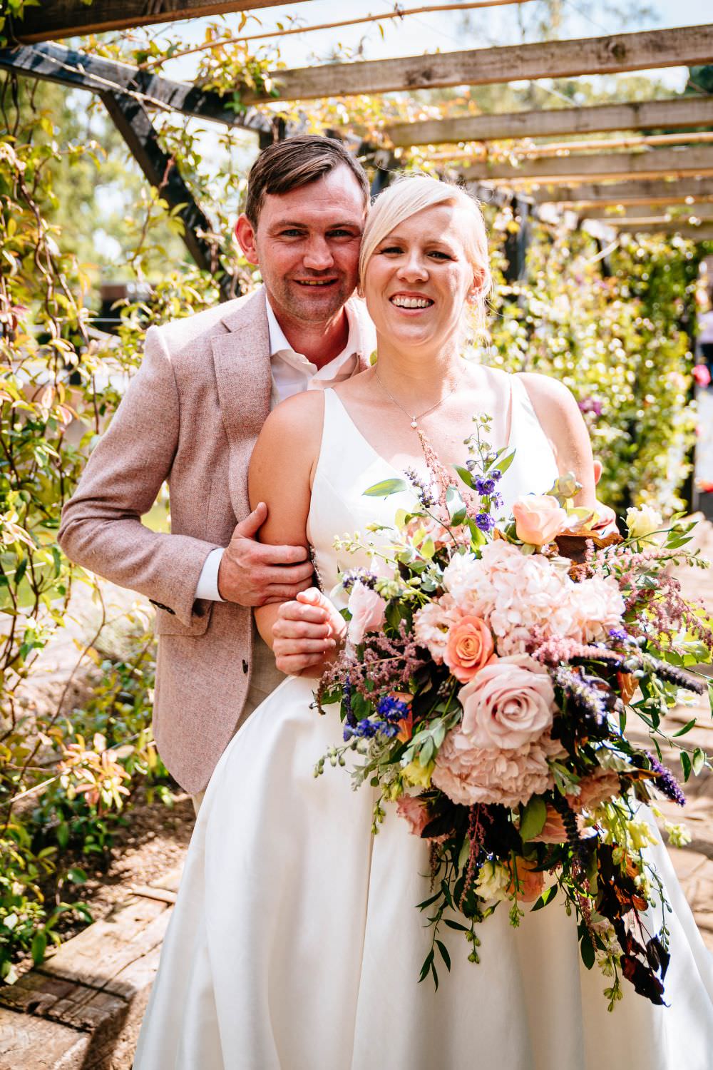 Bride Bridal V Neck Justin Alexander Dress Gown A Line Pink Salmon Custom Suit Groom Trailing Bouquet Carousel Wedding Sarah Legge Photography