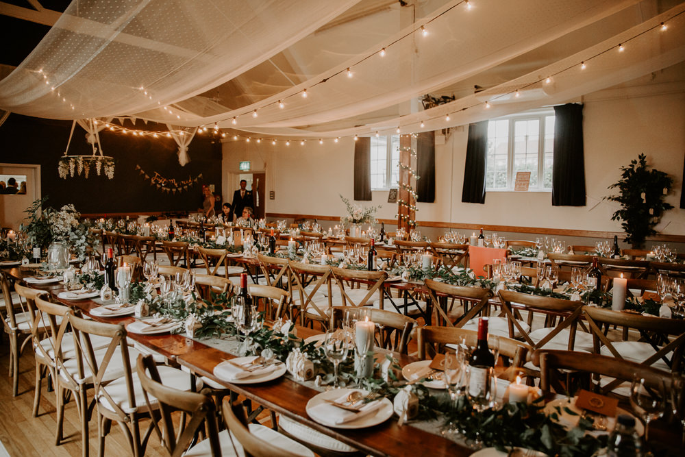 Ceiling Draping Festoon Lighting Wooden Cross Back Chairs Greenery Tables Willingale Village Hall Wedding Photographer Liam Gillan