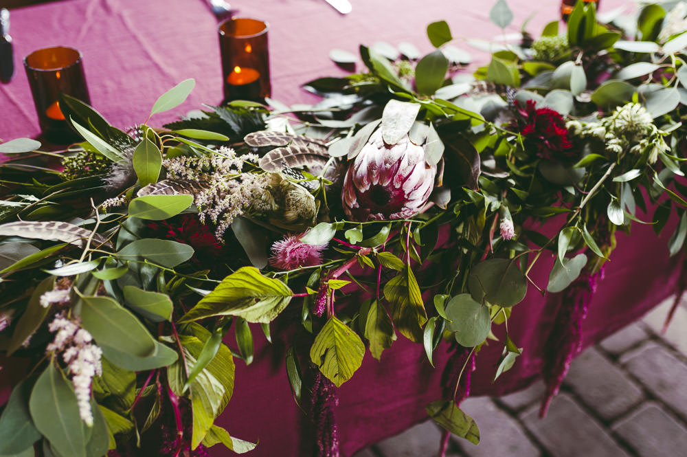 Top Table Red Burgundy Table Cloths Greeenery Foliage Protea Flowers Kingshill Barn Wedding Sandra Reddin Photography