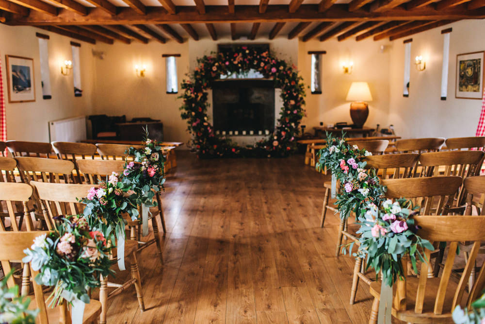 Moon Gate Flower Arch Ceremony Aisle Flowers Greenery Foliage Sweetpeas Freesias Peony Rose Burgundy Pink Outbuildings Wedding Jessica O'Shaughnessy Photography