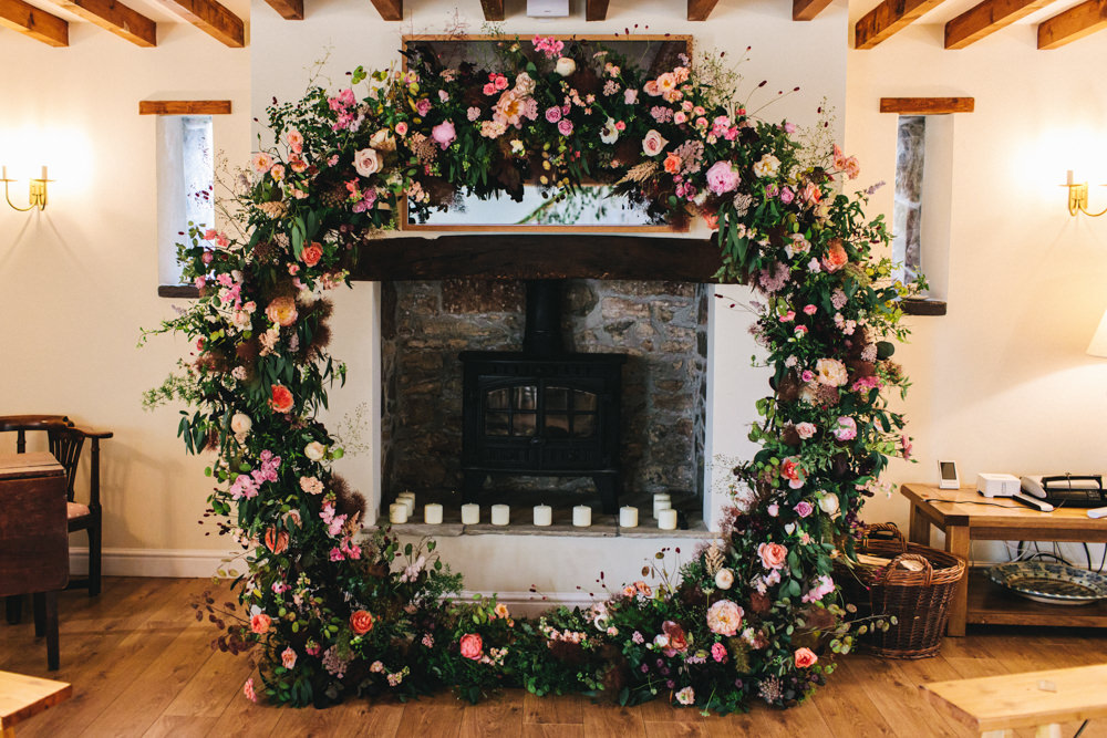 Moon Gate Flower Arch Ceremony Aisle Flowers Greenery Foliage Sweetpeas Freesias Peony Rose Burgundy Pink Outbuildings Wedding Jessica O'Shaughnessy Photography