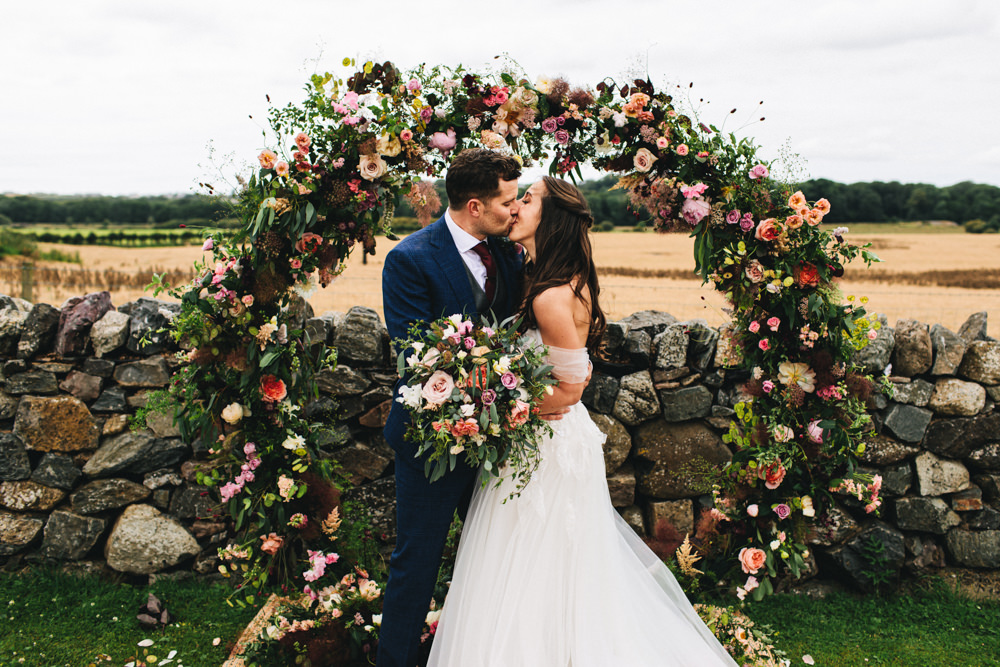Outbuildings Wedding Jessica O'Shaughnessy Photography Moon Gate Flower Arch Ceremony Aisle Flowers Greenery Foliage Sweetpeas Freesias Peony Rose Burgundy Pink