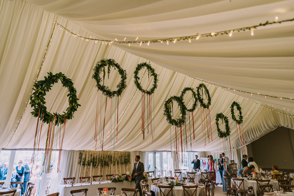 Marquee Hanging Wreaths Hoops Suspended Greenery Foliage Ribbon Fairy Lights Crafty Village Hall Wedding Dot and Scolly Photography