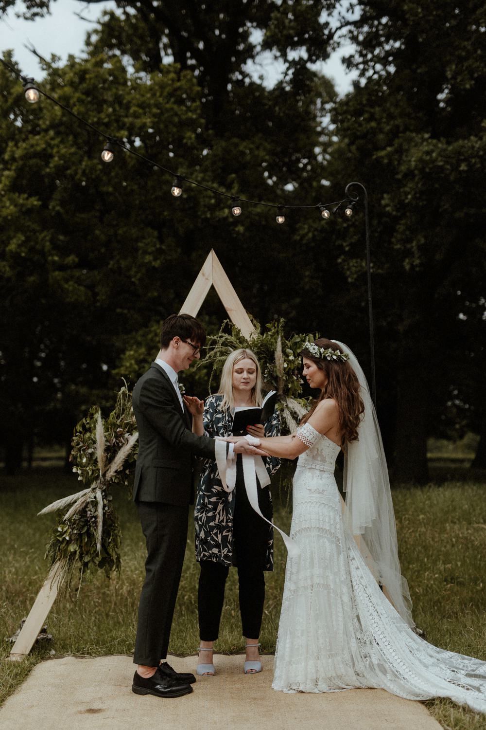 Backdrop Triangle Flowers Festoon Lights Backdrop Ceremony Outdoor Wedding UK Olivia and Dan Photography