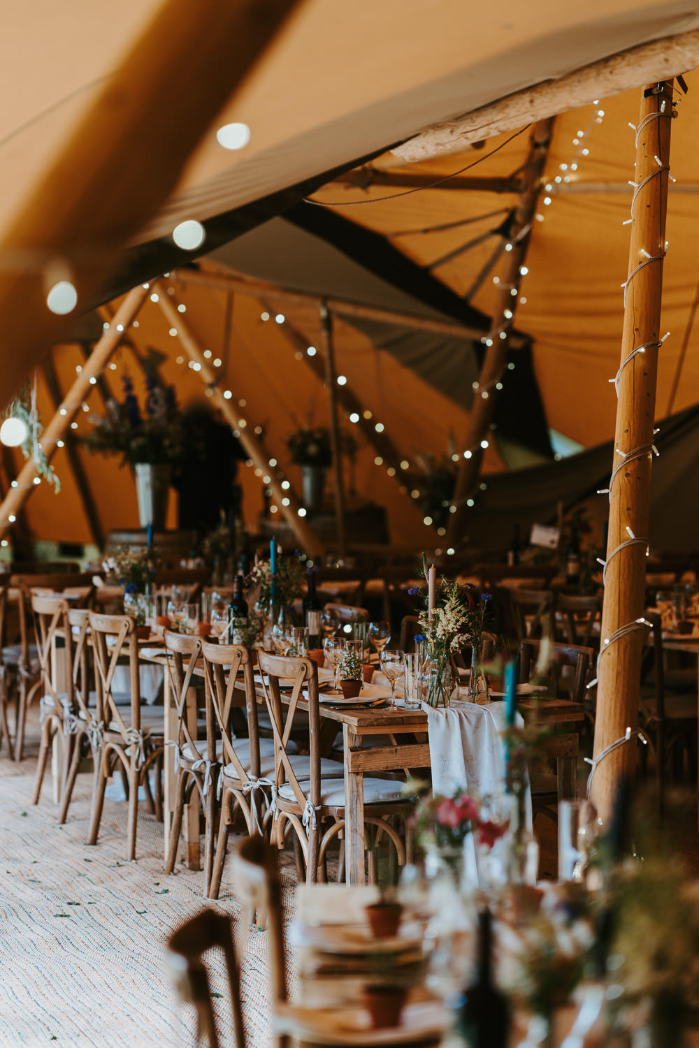 Tipi Wooden Long Tables Fairy Lights Flowers Country Festival Wedding Jonny Gouldstone Photography