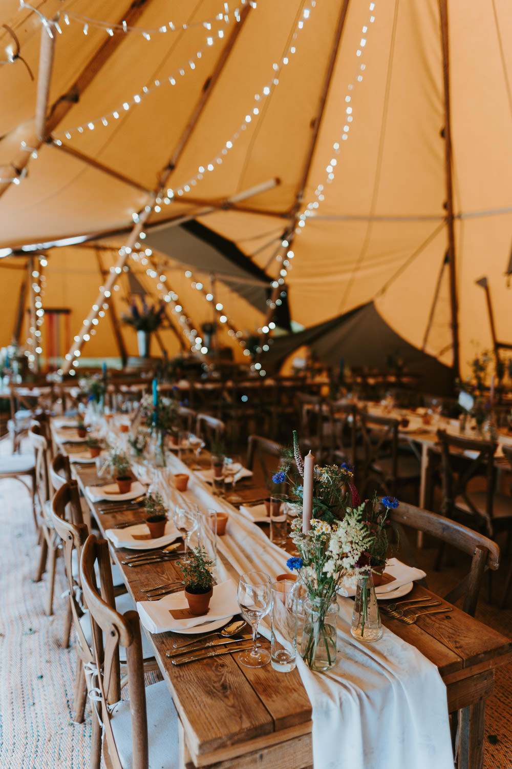 Tipi Wooden Long Tables Fairy Lights Flowers Country Festival Wedding Jonny Gouldstone Photography
