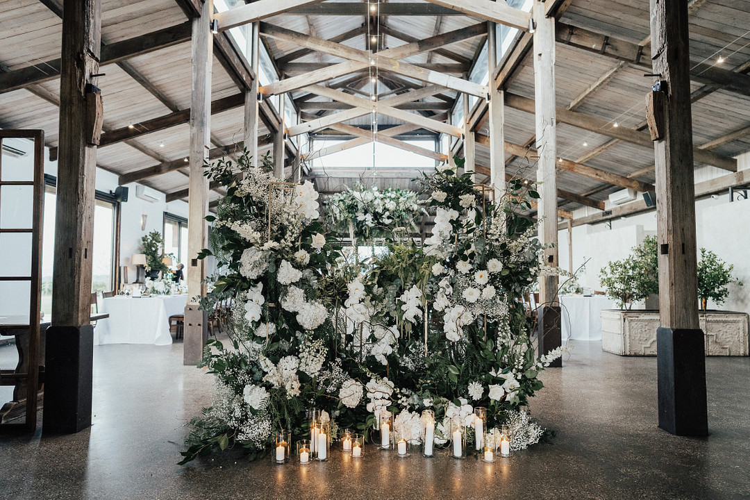 Flower Installation Backdrop Greenery White Flowers Candles Stones of the Yarra Valley Wedding Rick Liston Photography