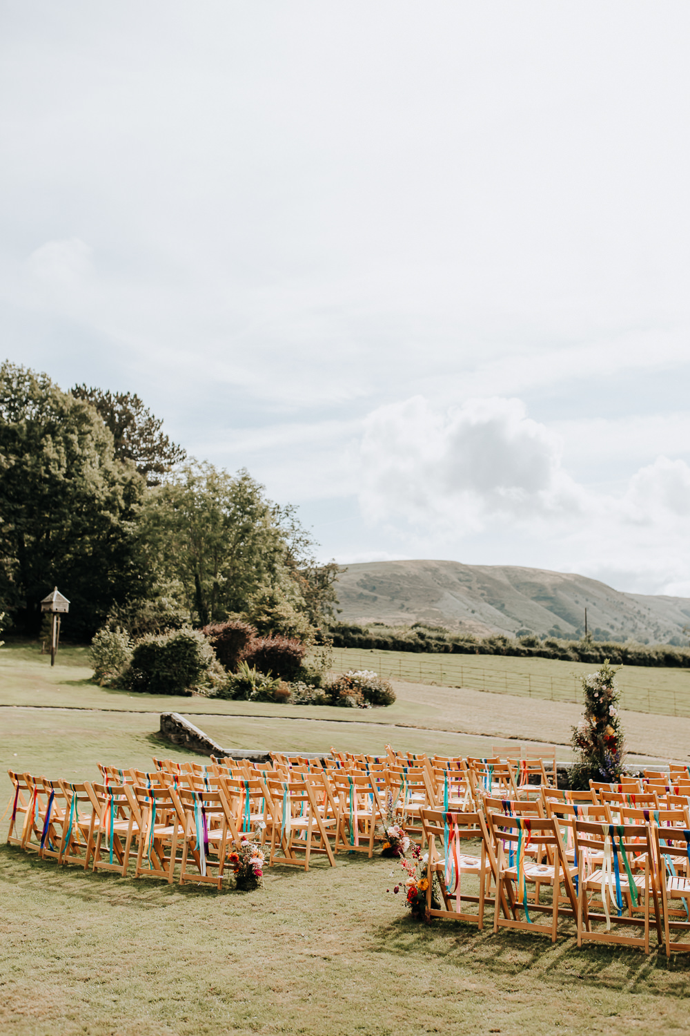 Wooden Chairs Rainbow Ribbons Flowers Aisle Ceremony Outdoors Plas Dinam Wedding Wyldbee Photography