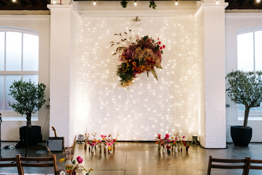 Ceremony Flowers Colourful Fairy Light Wall London Warehouse Wedding Kristian Leven Photography