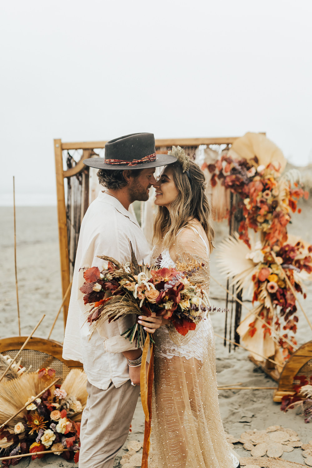 Boho Beach Elopement Rebecca Carpenter Photography Flower Arch Backdrop Flower Arrangement Orange Rose Palm Leaf