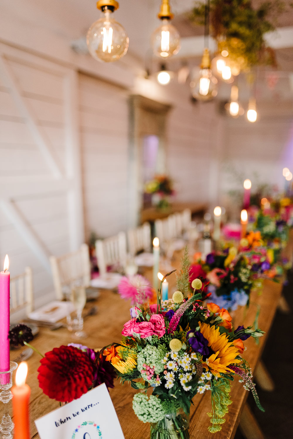 Wedding Flower Table Decoration Centrepiece Long Candles Colourful Festoon Lights Bashall Barn Wedding Rachel Kenyon Photography