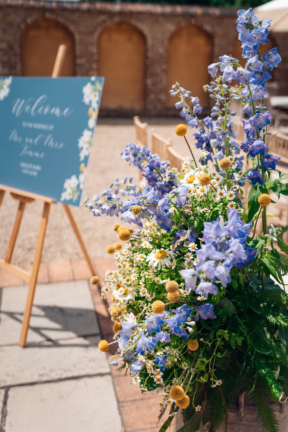 Craspedia Daisies Delphiniums Flowers Arrangement Ceremony Sign Blue Yellow Wedding Ideas EmilyCollettPhotography