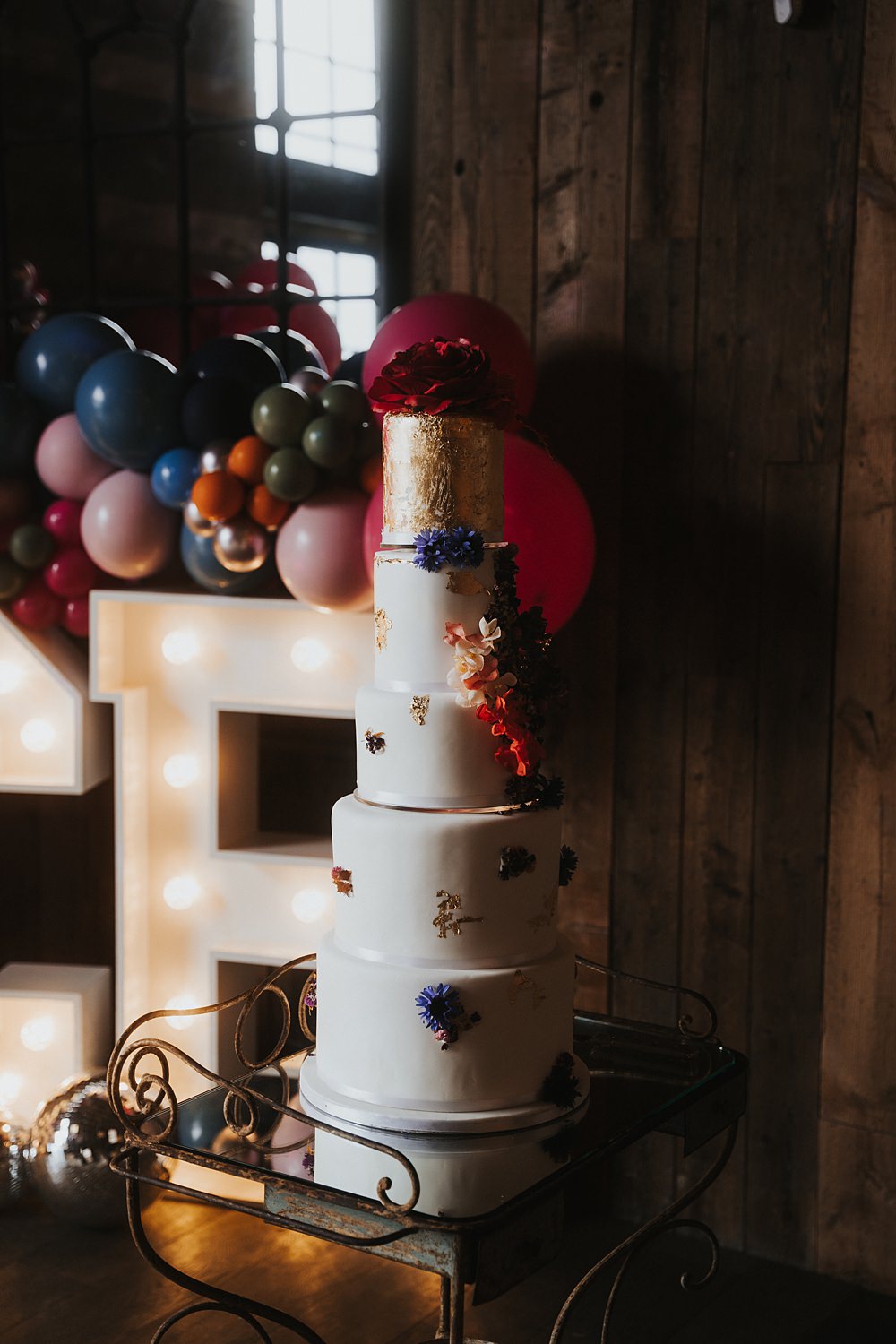 Tall White Cake Gold Leaf Flowers Fun Colourful Barn Wedding Firewood Film