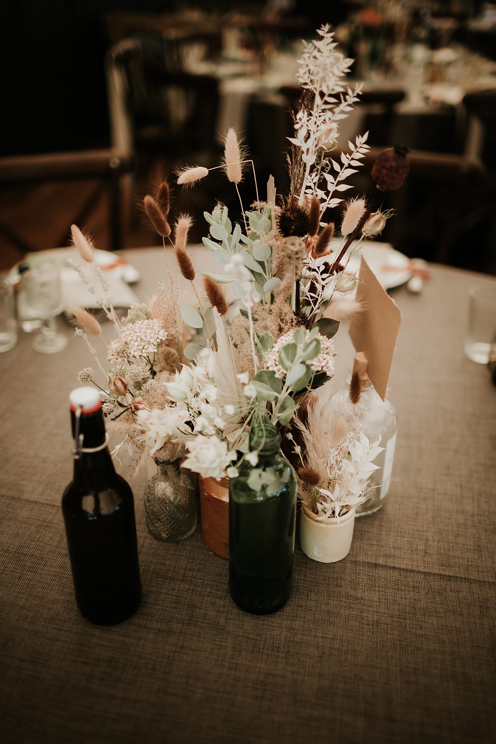 Centrepiece Flowers Bottles Dried Palms Kent Woodland Wedding Paul Fuller Photography