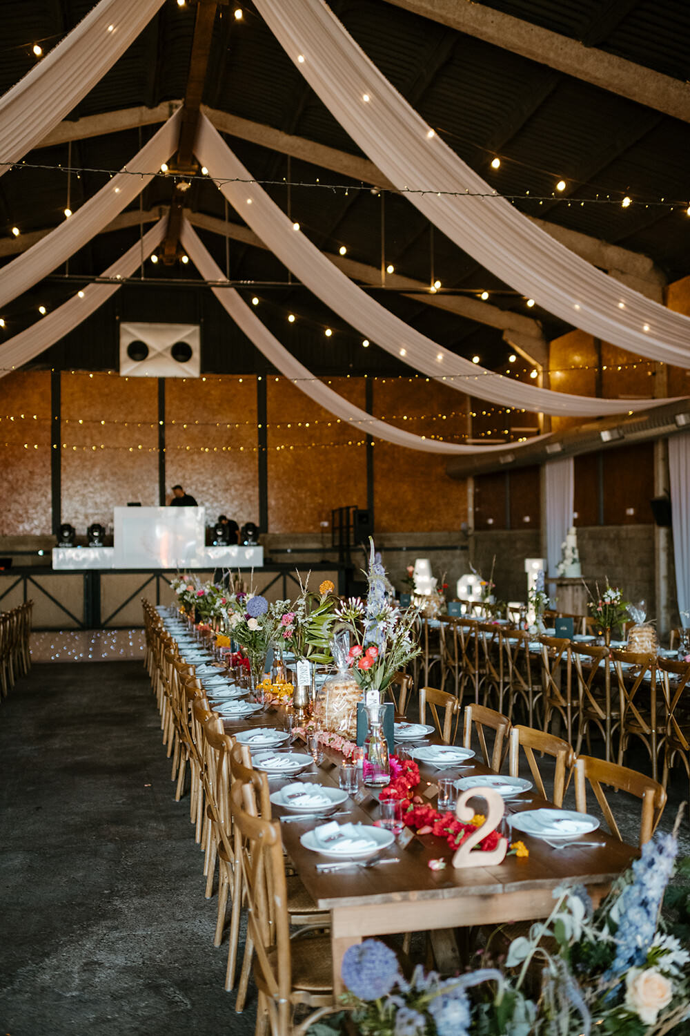Long Wooden Tables Barn Decor Flowers Fabric Lights Indian Lithuanian Wedding Ellie Gillard Photography