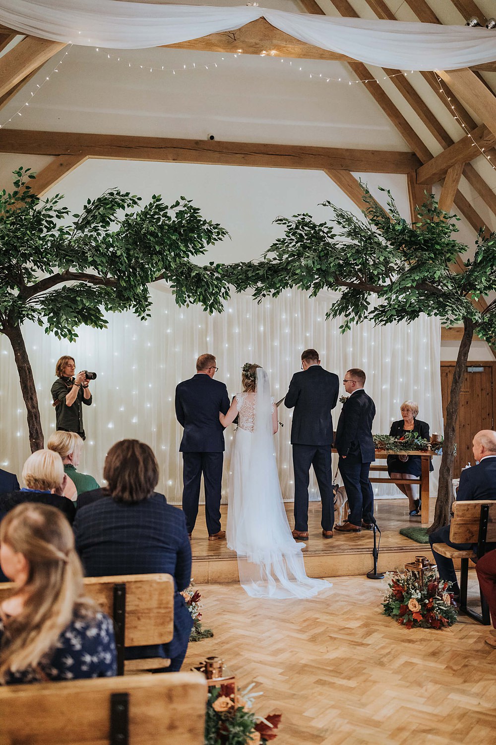 Ceremony Aisle Flowers Trees Fairy Light Curtain Old Kent Barn Wedding Olegs & Rita Photography
