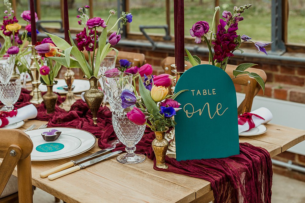 Somersbury Barn Wedding Thorn and Found Flowers Candles Table Decor Green Red Purple Blue Gold
