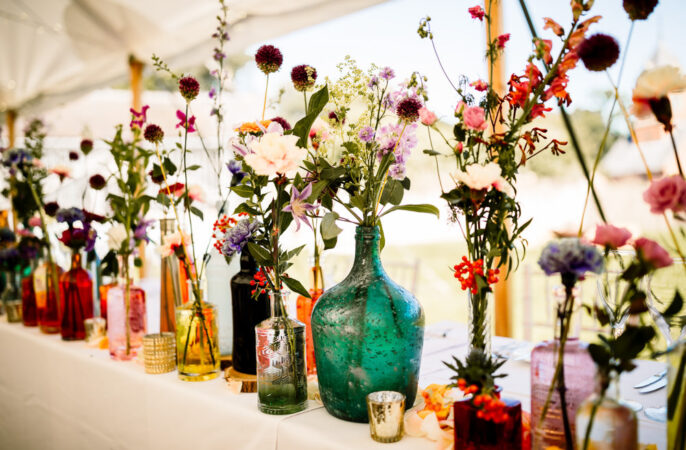 Wedding Table Decor Flowers Colourful Bottles Candles Hayley Baxter Photography