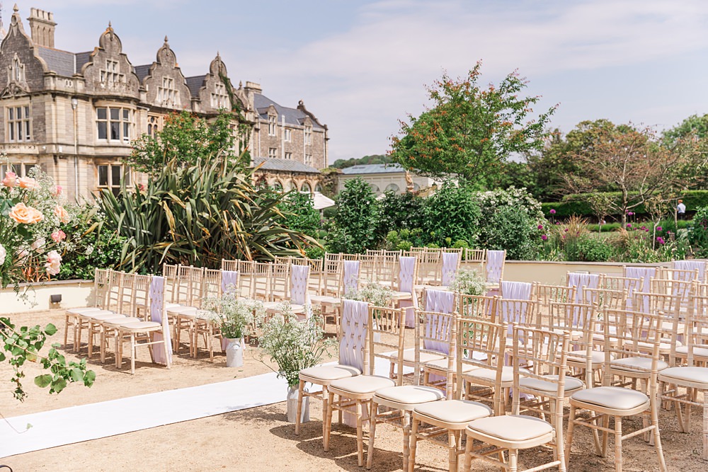 English South African Wedding James and Kerrie Photography Outdoor Ceremony Chairs Covers Flowers Rug Aisle