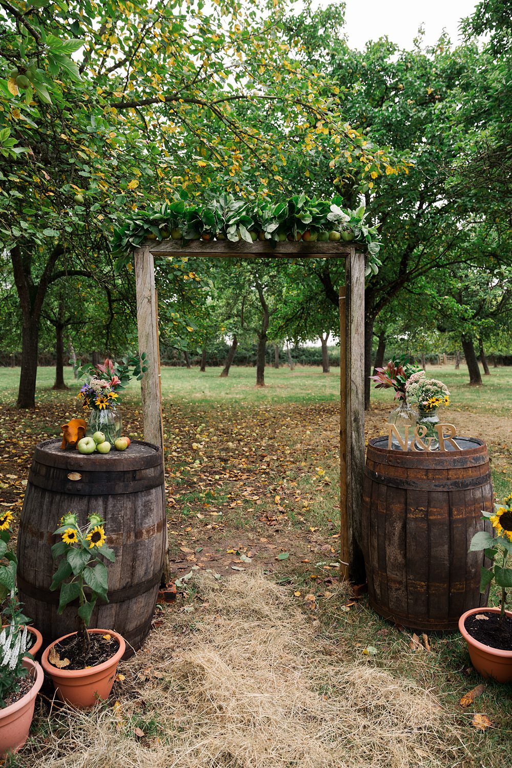 Orchard Wedding Just James Weddings Arch Wooden Barrels Flowers CEremony Decor
