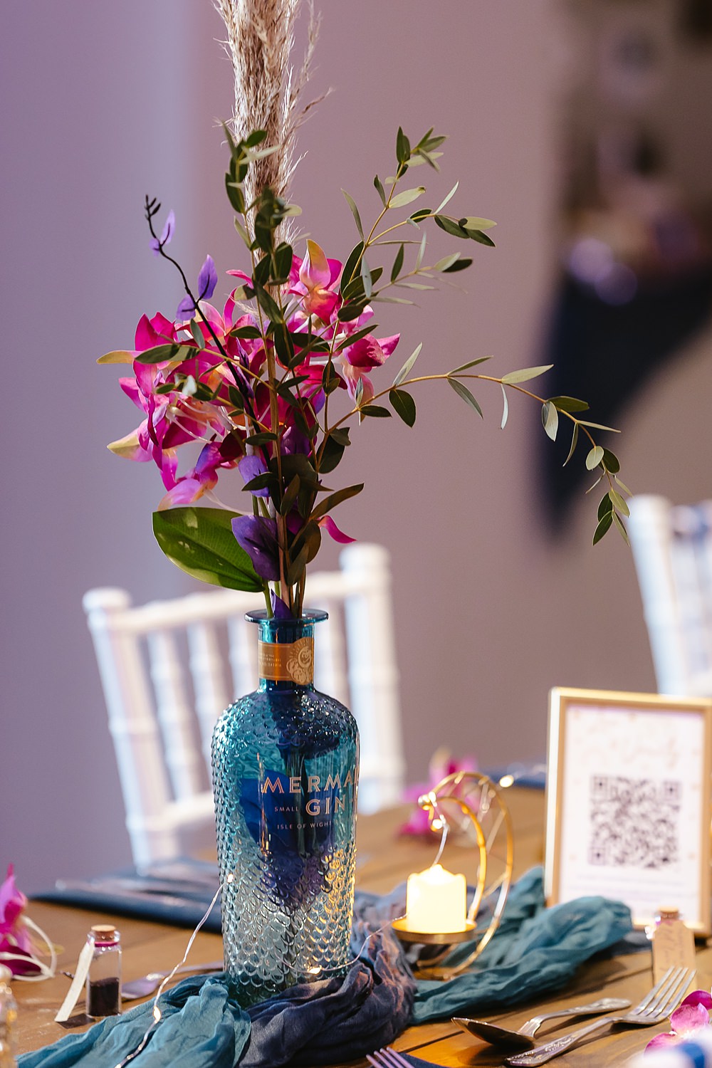 Stables at Ffolkes Wedding Cherrelle Blake Photography Table Decor Colourful Pink Blue Purple Flowers Gin Bottle Candles Runner