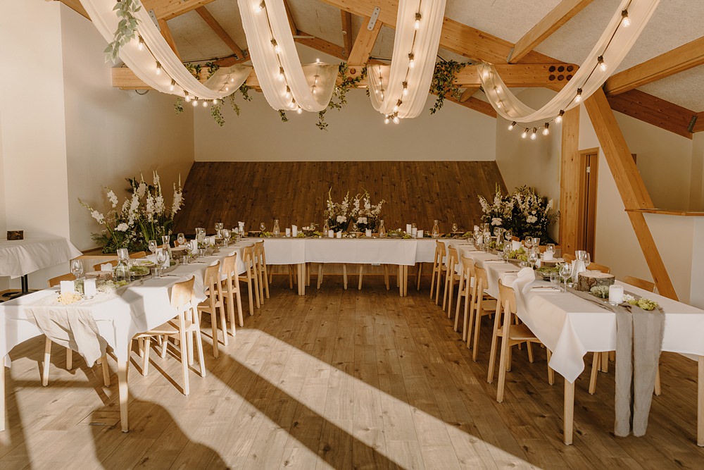 Hotel Katla Wedding ISKRA Photography Modern Reception Room Wood Beams Long Tables Lights Drapes Flowers