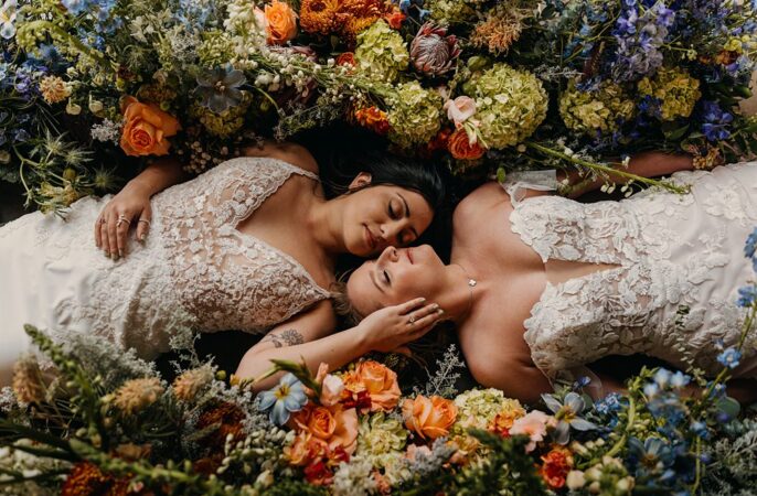 The Red Earth Venue Wedding Adventure and Vow Brides Lay In Flowers