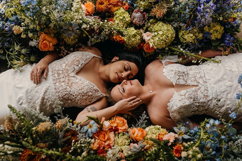 The Red Earth Venue Wedding Adventure and Vow Brides Lay In Flowers