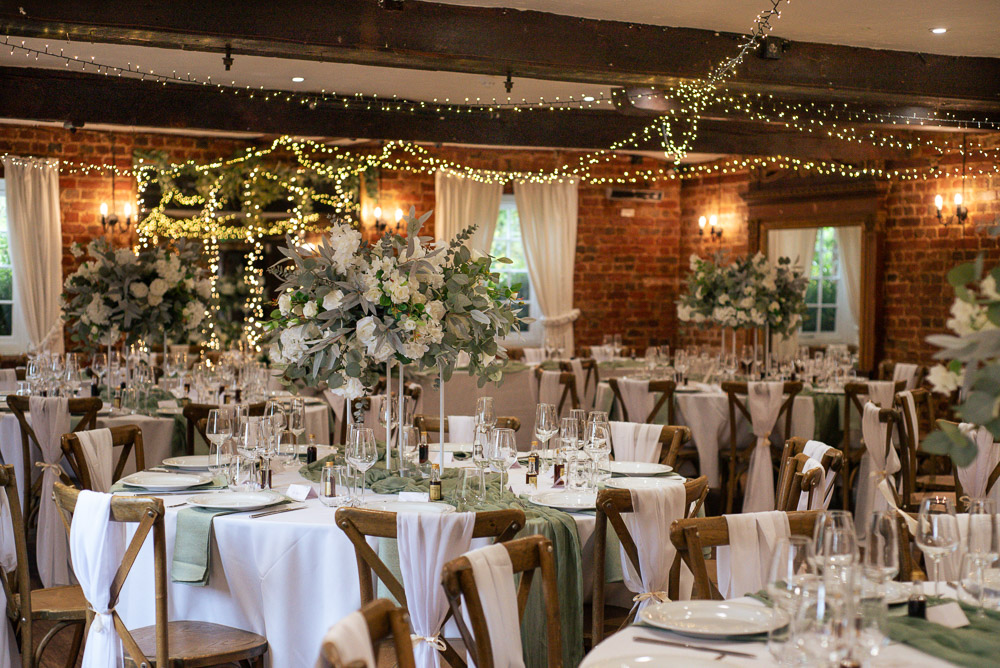 The Old Mill Aldermaston Wedding Nicola Belson Photography Fabric Chair Backs Green Linen White Roses Greenery Decor Tall Centrepiece