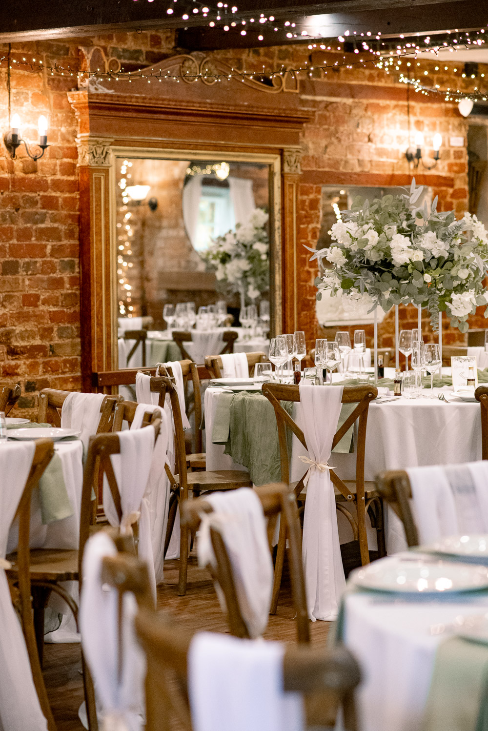 The Old Mill Aldermaston Wedding Nicola Belson Photography Fabric Chair Backs Green Linen White Roses Greenery Decor Tall Centrepiece